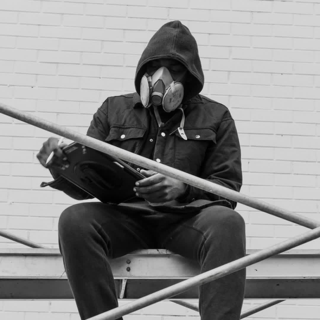 Dino working alone, mask on, sketching