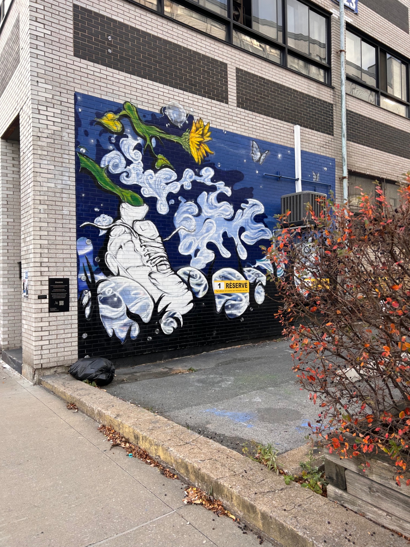 Évasion street mural with a white boot, sunflower and butterfly on a Montréal building façade