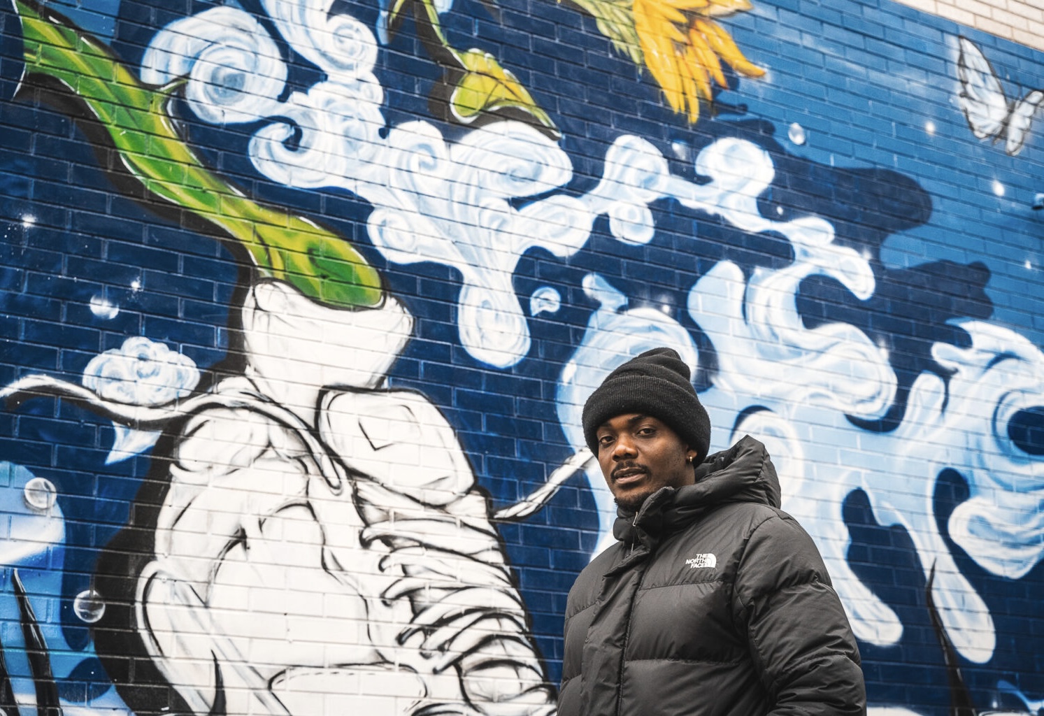 Artist in front of the Évasion mural