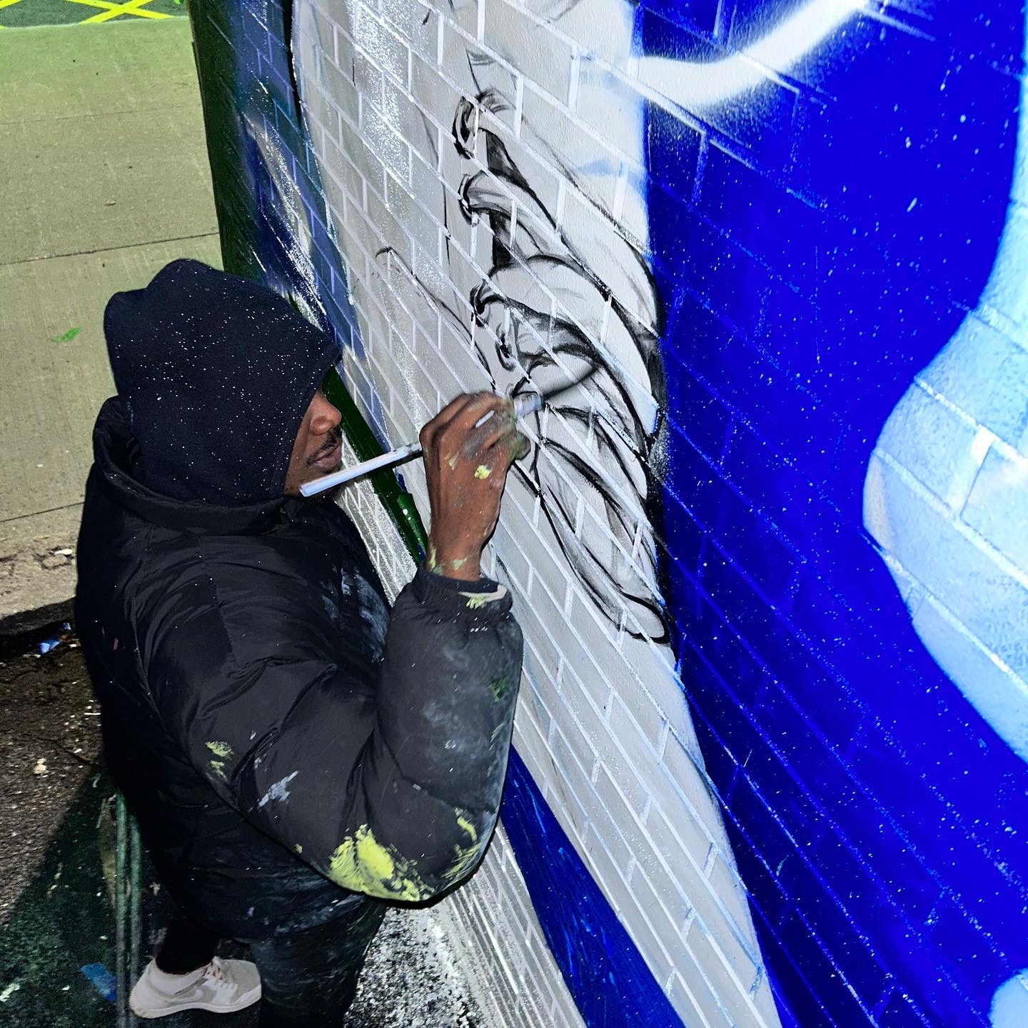 Hand painting the face on the mural at night